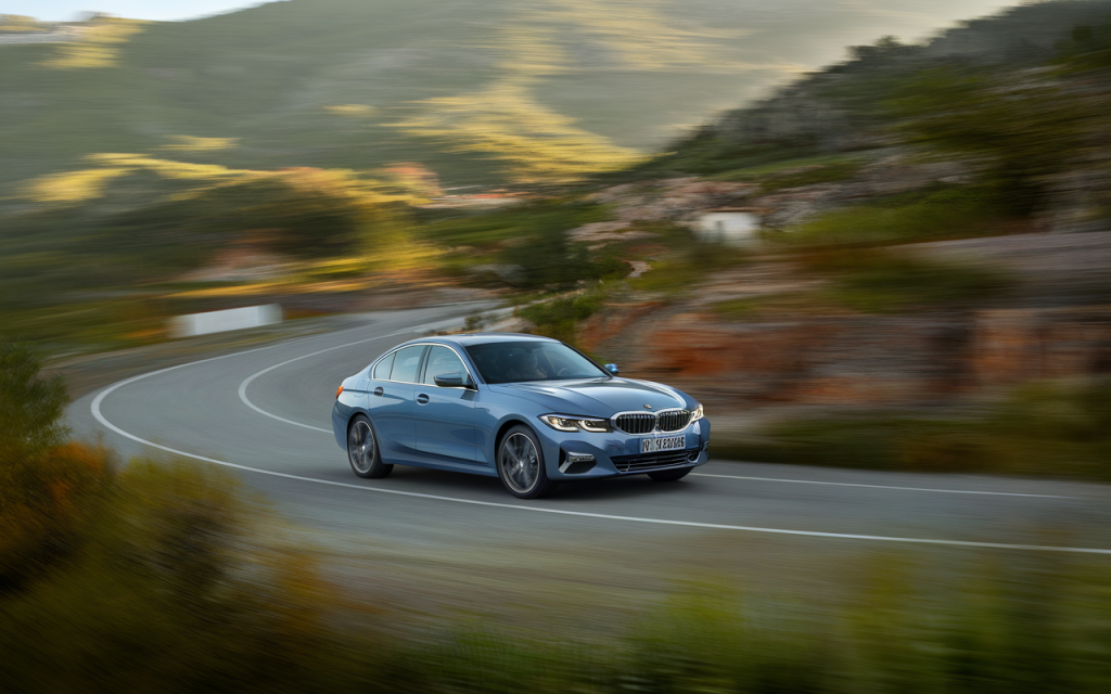 Vue latérale d'une BMW Série 3 2019 de couleur grise sur une route