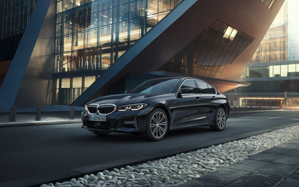 Vue latérale d'une BMW Série 3 noire garée sur la route