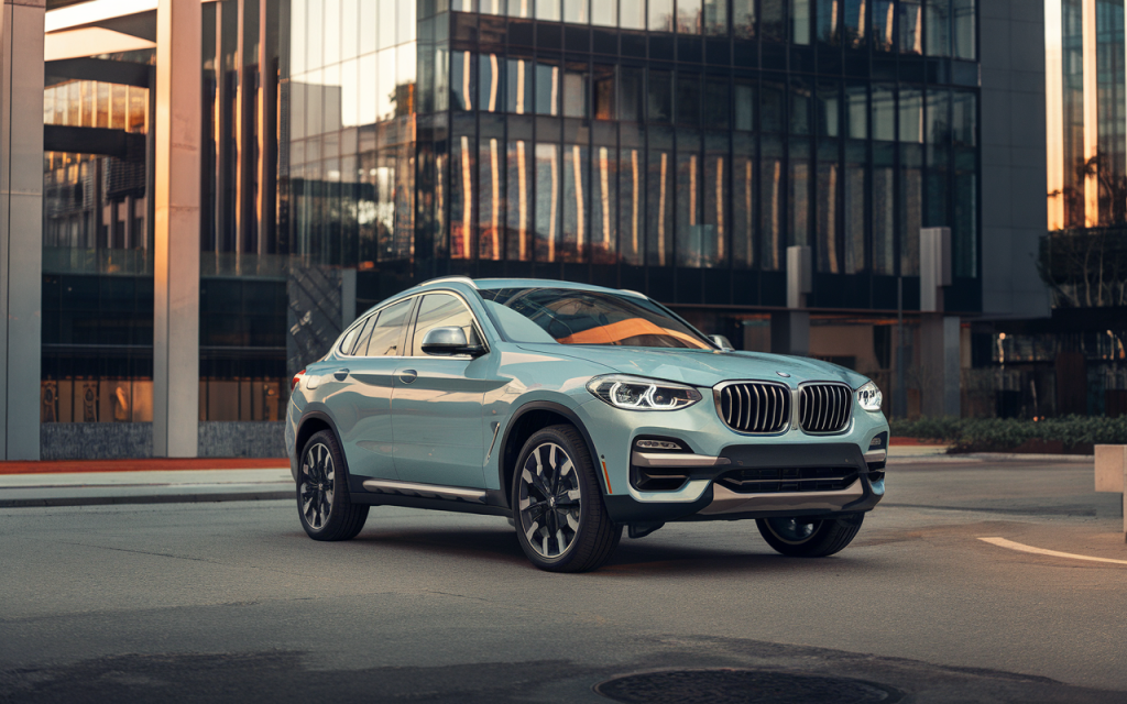 Vue latérale d’une BMW X4 de couleur noire stationnée en extérieur