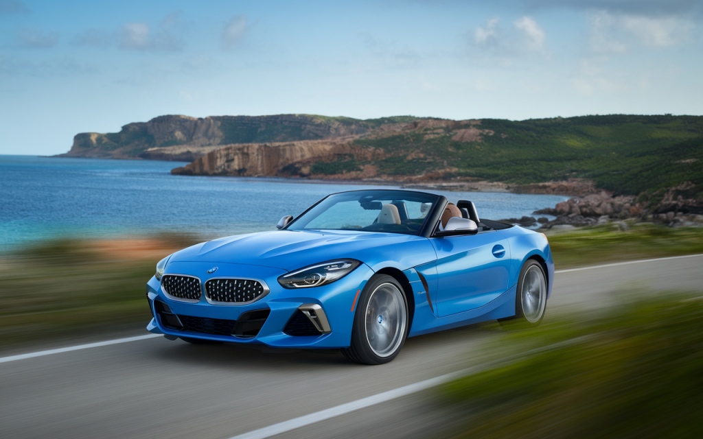 Vue latérale d'une BMW Z4 de couleur bleue sur une route de montagne