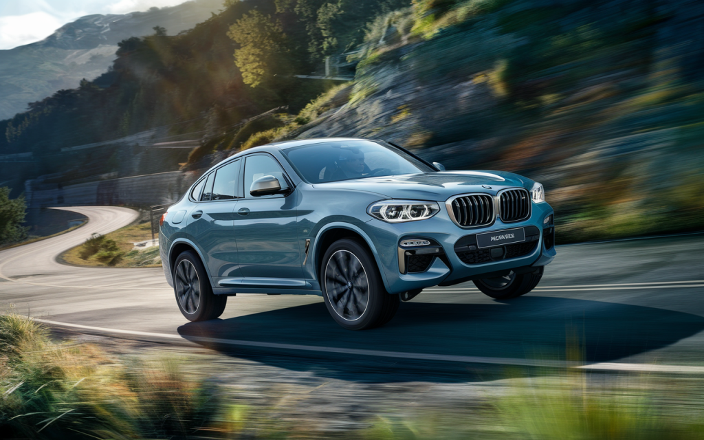 BMW X4 SUV en mouvement sur une route de montagne verdoyante